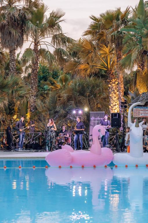 a band playing in a pool with a pink swan in the water at Toison D'or in Saint-Tropez