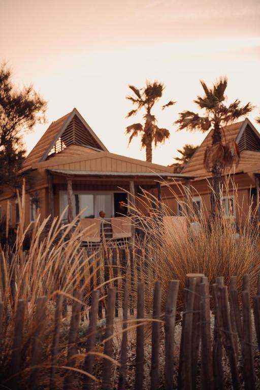 a wooden house with palm trees in front of it at Toison D'or in Saint-Tropez