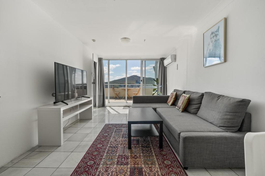 a living room with a couch and a flat screen tv at Private Room in a City Centre Duplex Apartment-3 in Canberra