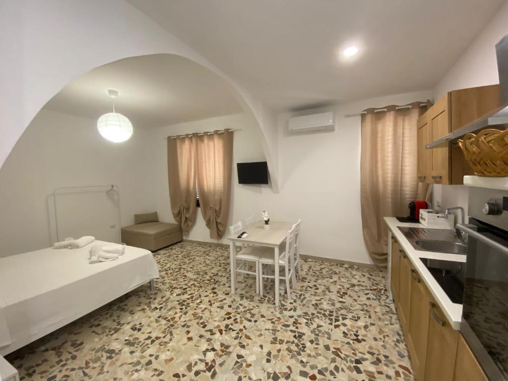 a room with a bed and a table in a kitchen at Da Peppino e Nicchella in Marina di Camerota
