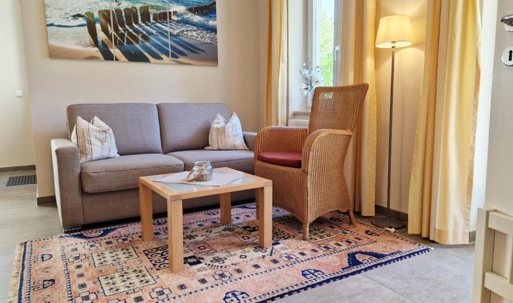 un soggiorno con divano, 2 sedie e tavolo di Ferienwohnung Seeadler Nr. 8 a Kühlungsborn