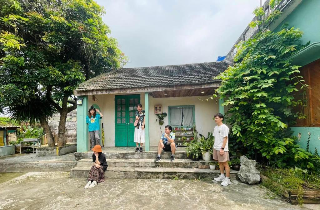 eine Gruppe von Menschen, die vor einem kleinen Haus stehen in der Unterkunft Mơ Homestay - Đầm Vân Long in Vân Lung