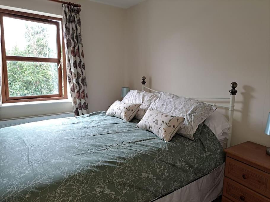 a bedroom with a bed with pillows and a window at Donard View, Newcastle in Newcastle