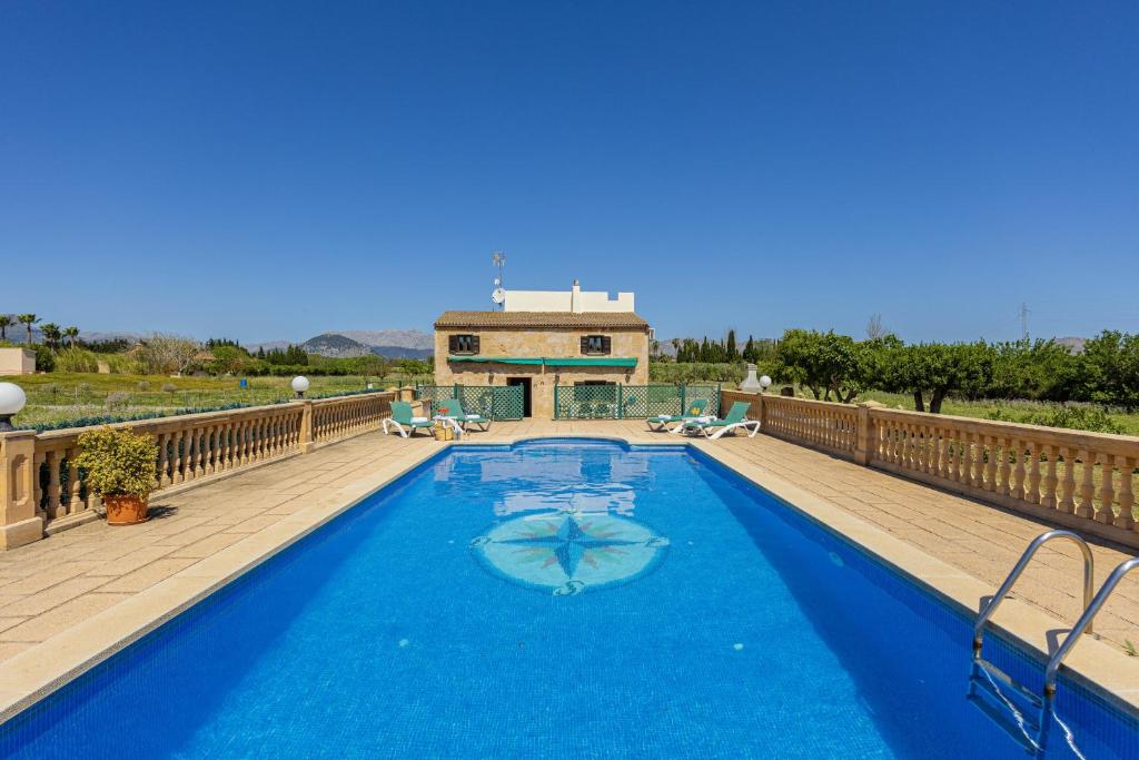 une grande piscine bleue sur une terrasse en bois dans l'établissement Villa Can Gosp / Sa Caseta d'en Mateu, à Alcúdia