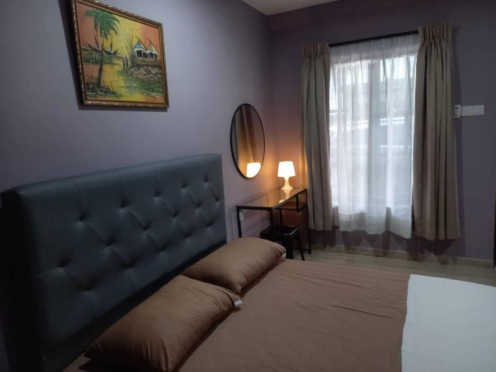a bedroom with a bed and a window at Tambun Homestay in Tambun