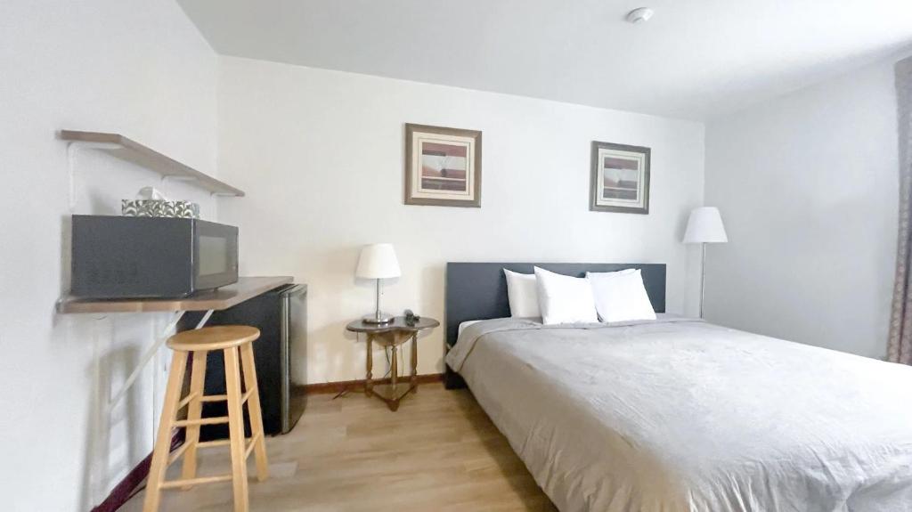 Habitación de hotel con cama y TV en Commons Inn, en Halifax