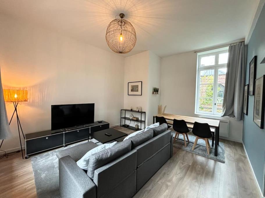 un salon avec un canapé et une télévision à écran plat dans l'établissement Vieux-Lille Appartement rénové avec une chambre, à Lille