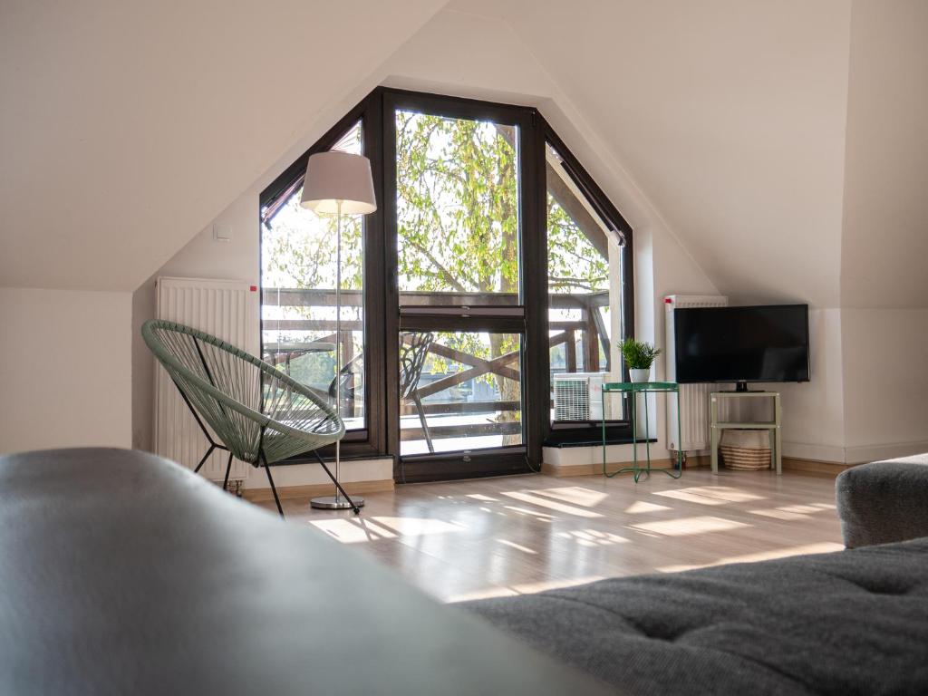 a living room with a chair and a large window at Villa Bella Italia III in Mikołajki