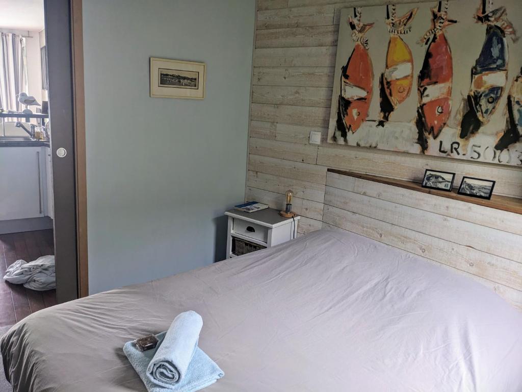 a bedroom with a bed with a towel on it at La Vigie sur le Port in Granville