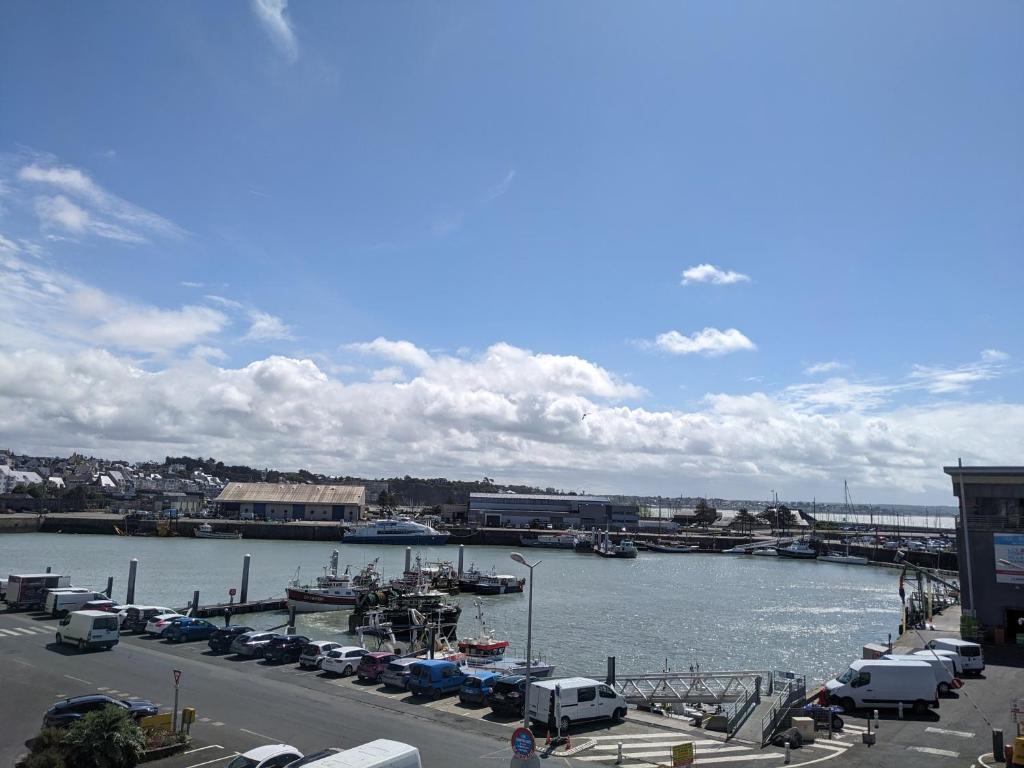 a marina with cars parked next to the water at La Vigie sur le Port in Granville