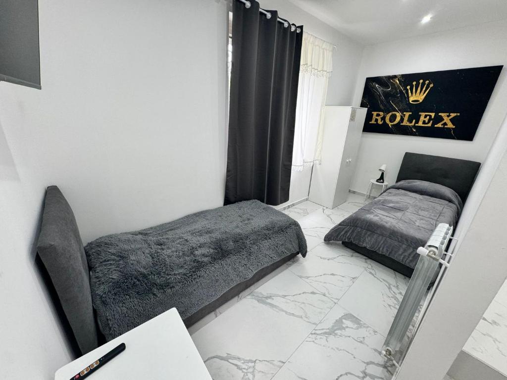 a bedroom with two beds and a sign that reads rolex at Villa Life in San Donato Milanese