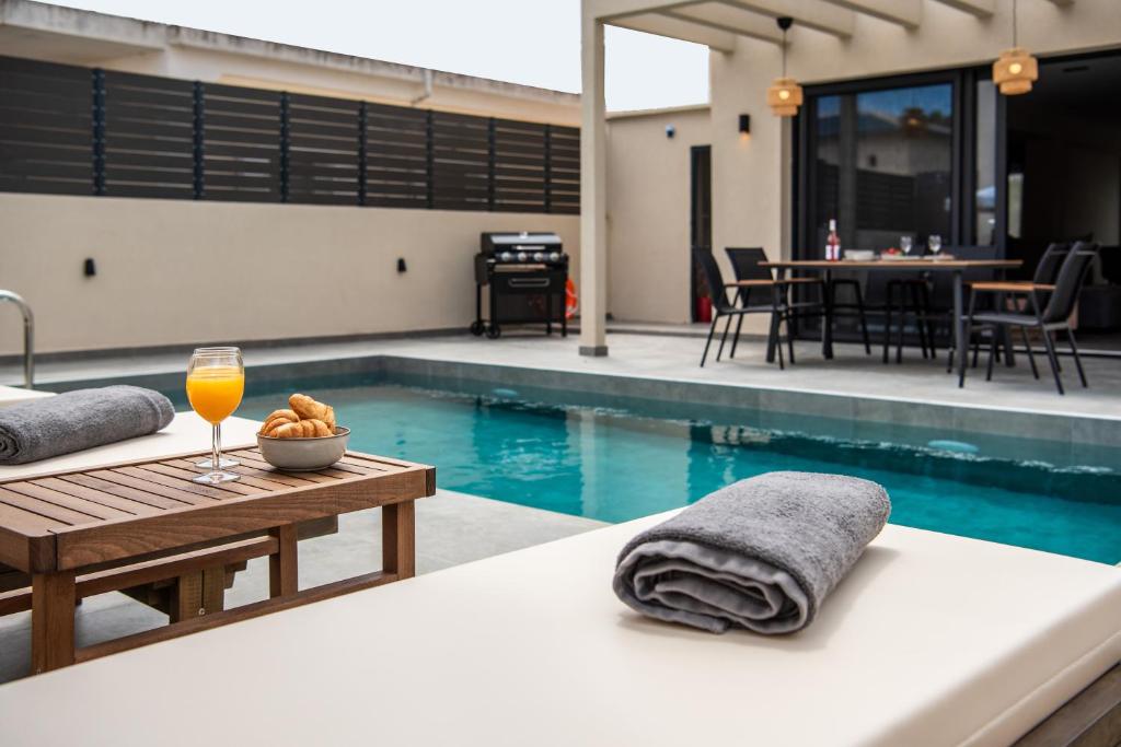 a swimming pool with a table and a glass of wine at Villa Linea Verde I by Sealand Villas in Tsilivi