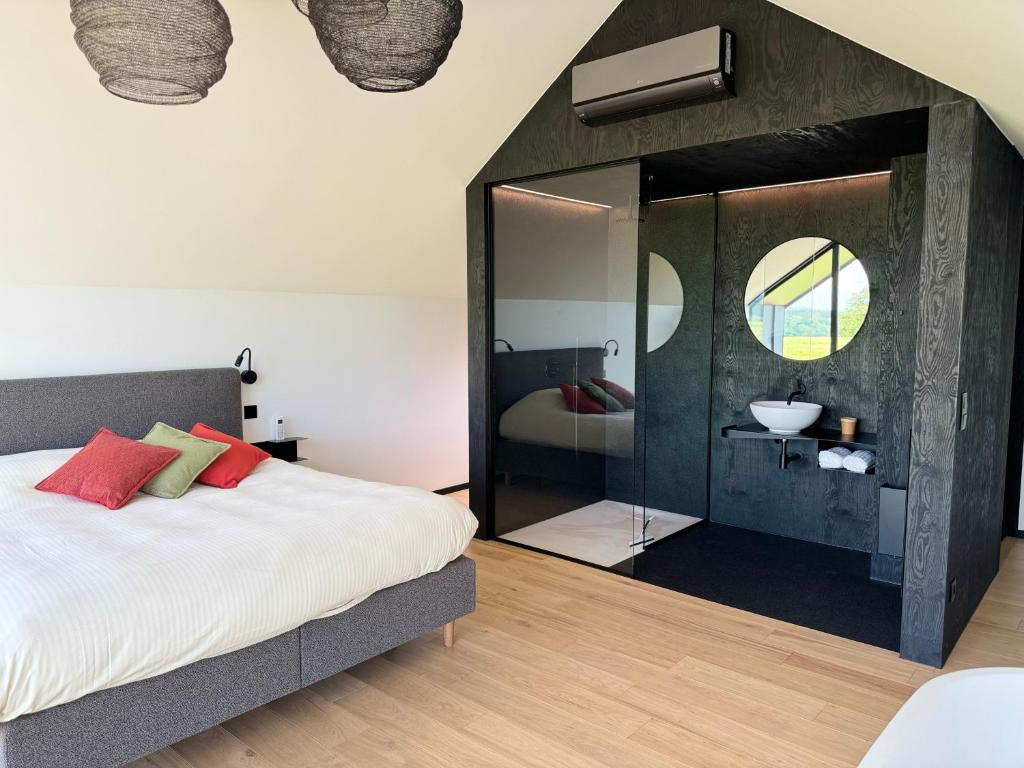 1 dormitorio con 1 cama y baño con lavamanos en Durbuy insolite - Romantic Escape, en Durbuy