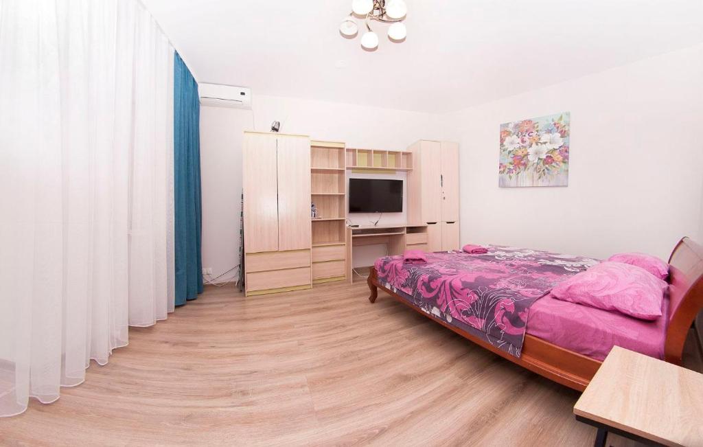 a bedroom with a bed and a desk and a tv at apartments on Chkalova in Dnipro