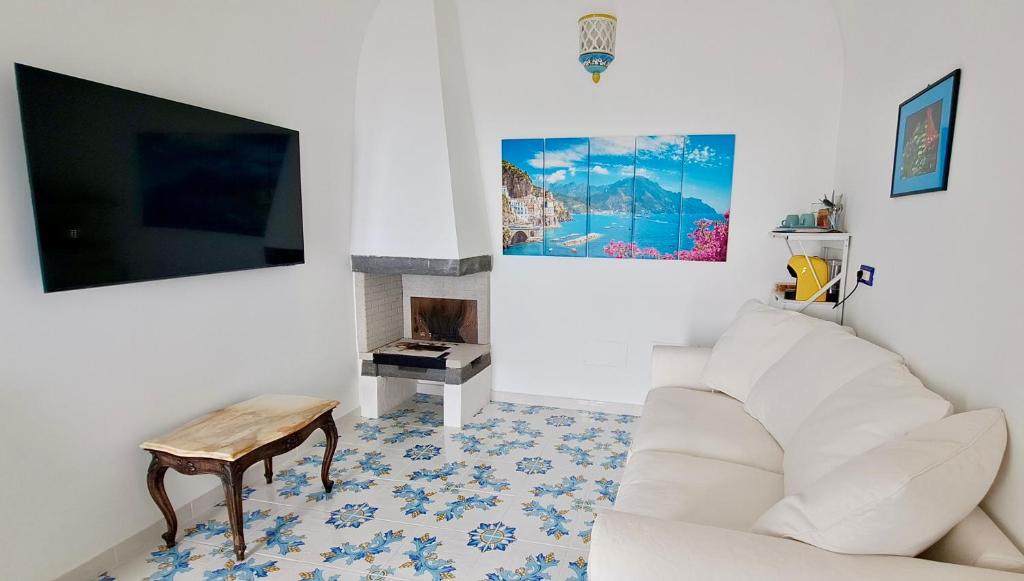 salon z białą kanapą i kominkiem w obiekcie Relais Amalfi Coast w mieście Conca dei Marini