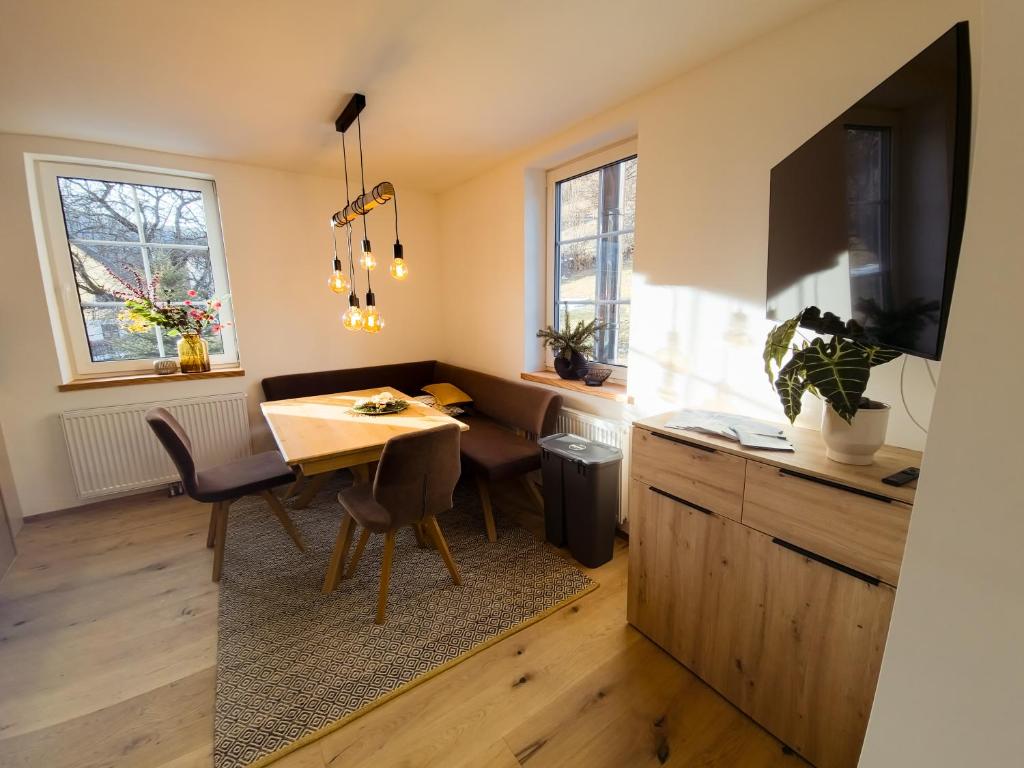 eine Küche mit einem Tisch und einem Esszimmer in der Unterkunft Apartment Neuwirthof - rustikaler Charme in Sankt Georgen ob Murau
