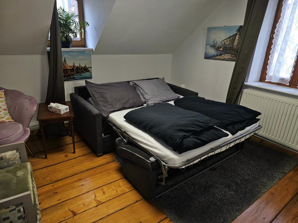 a bed sitting in a room with a couch at Petit Paradis Croneuva in Strasbourg