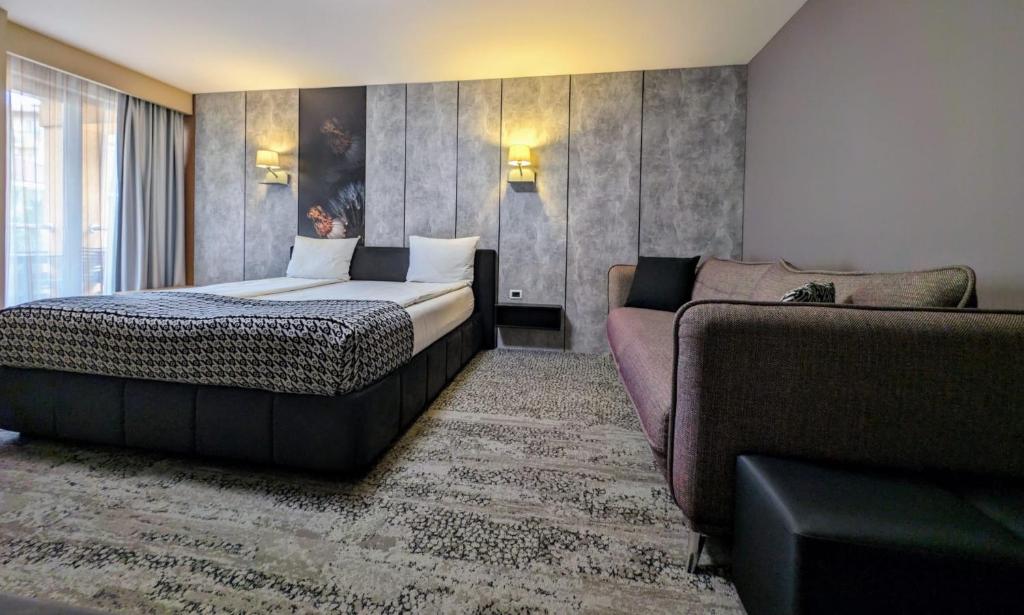 une chambre d'hôtel avec un lit et un canapé dans l'établissement Vila Topaz, à Băile Felix