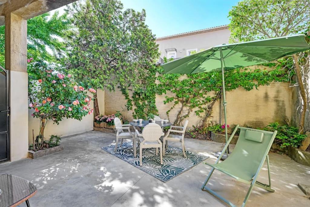 un patio avec une table, des chaises et un parasol dans l'établissement Lino - Terrasse - AC Clim - Wi-Fi, à Avignon