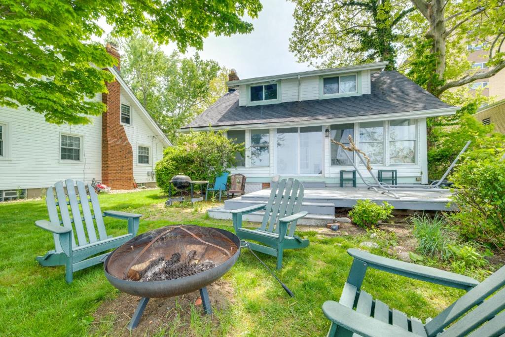 un patio trasero con sillas y una hoguera en Coastal Lake Erie Cottage with Amazing Water Views! en Euclid