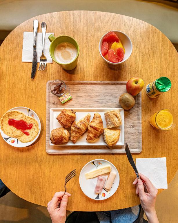 a person sitting at a table with plates of food at ibis Styles Paris 16 Boulogne in Paris