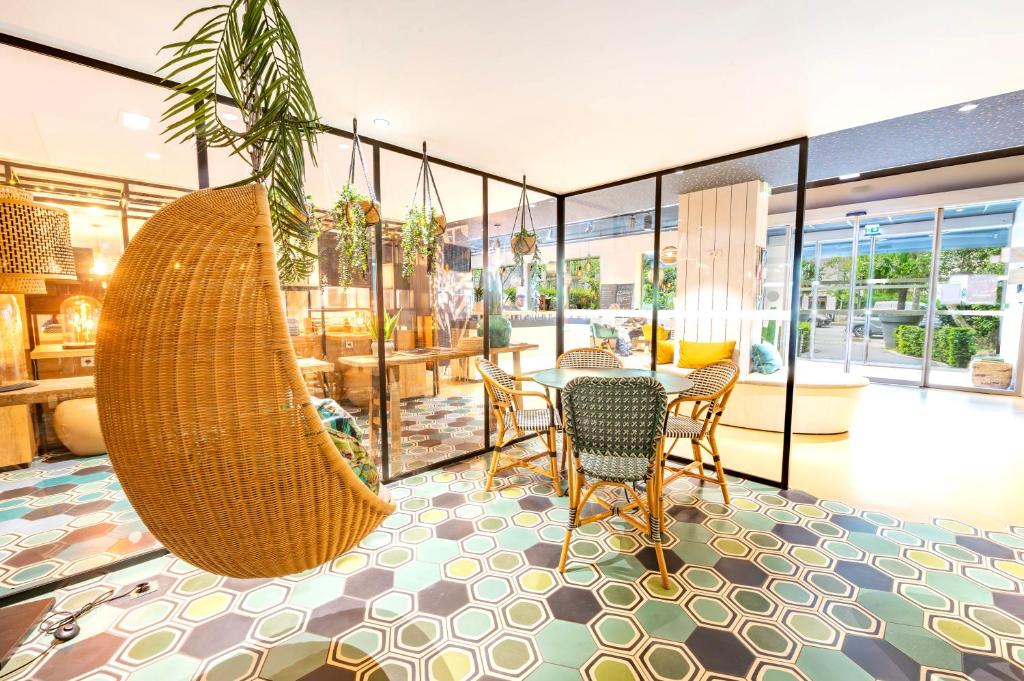 a room with a table and chairs and a hammock at ibis Styles Paris 16 Boulogne in Paris