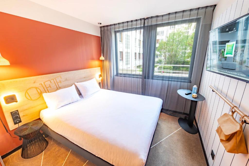 sypialnia z dużym łóżkiem i oknem w obiekcie ibis Styles Paris 16 Boulogne w Paryżu