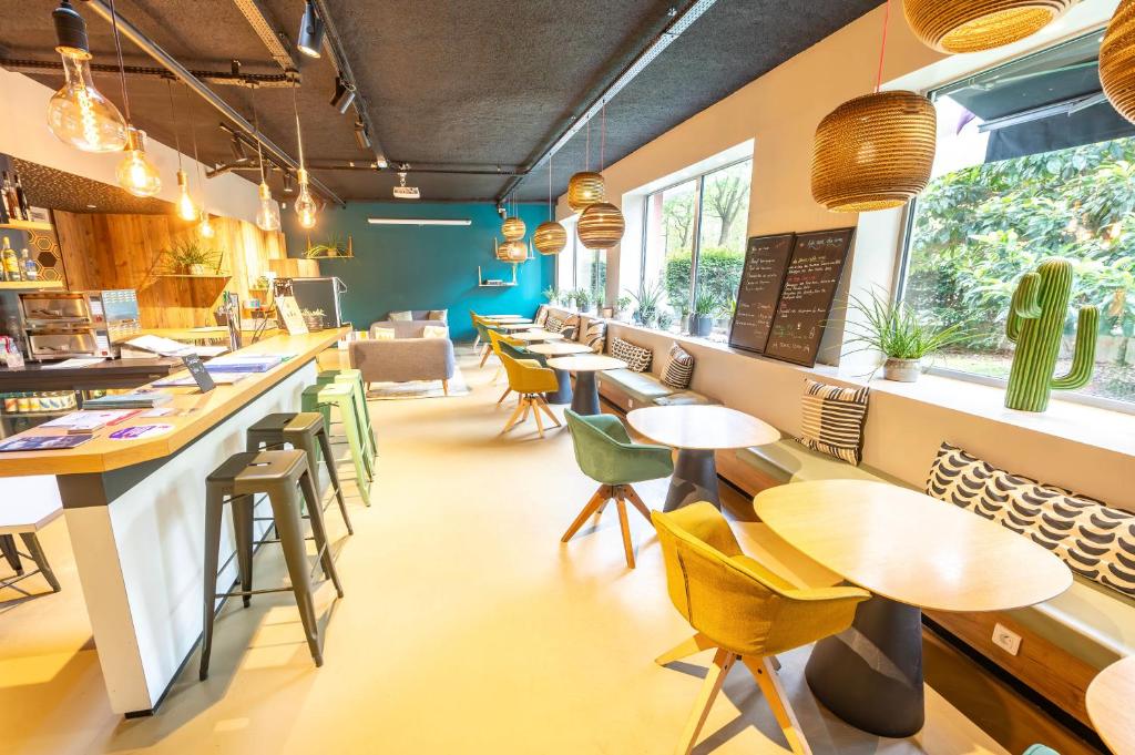 a restaurant with tables and chairs and a counter at ibis Styles Paris 16 Boulogne in Paris