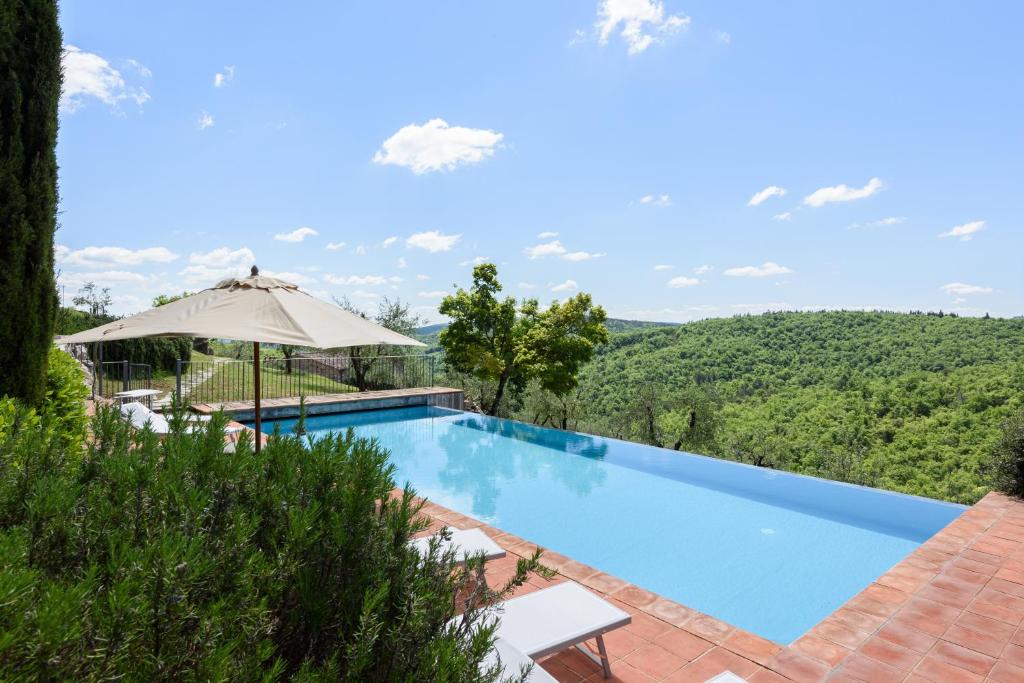 piscina con ombrellone e vista di Villa Cavallari a Radda in Chianti