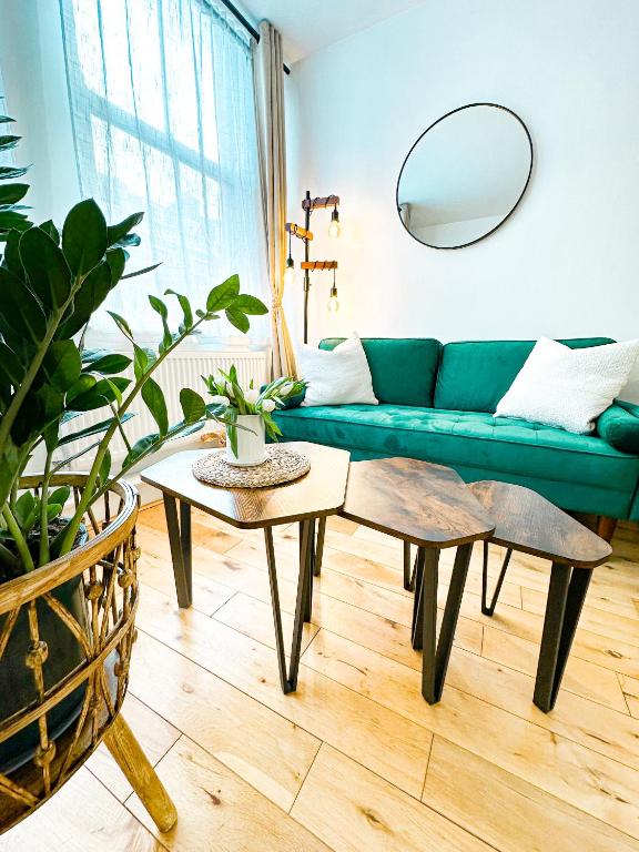 a living room with a green couch and a table at Minimalistic apartment in Crystal Palace in Crystal Palace