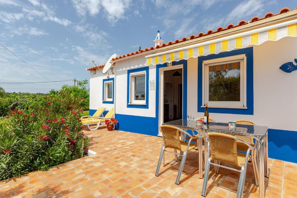 a patio with a table and chairs in front of a house at Casa Azul Beach and countryside in Armação de Pêra