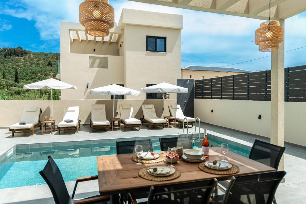 a patio with a table and chairs and a pool at Villa Linea Verde II by Sealand Villas in Tsilivi