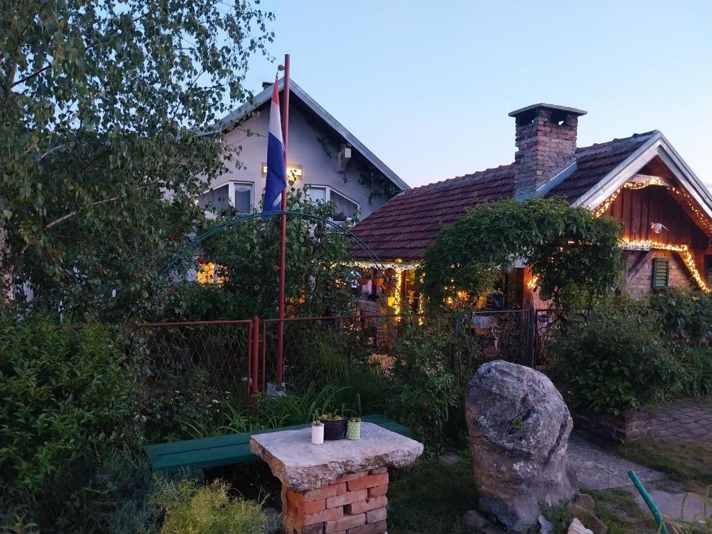 dom z kamienną ławką przed nim w obiekcie Apartment Ada bed & breakfast w mieście Gračac