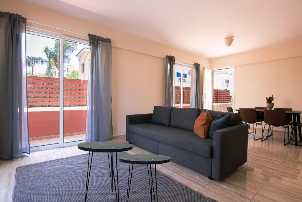 a living room with a couch and two tables at Phaedrus Living: Universal City Flat Alina in Paphos City
