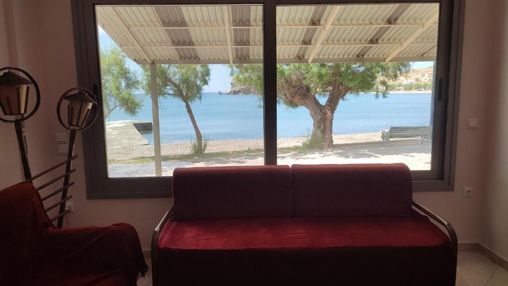a living room with a couch and a large window at Lesvos Tavari bay 2 in Tavari