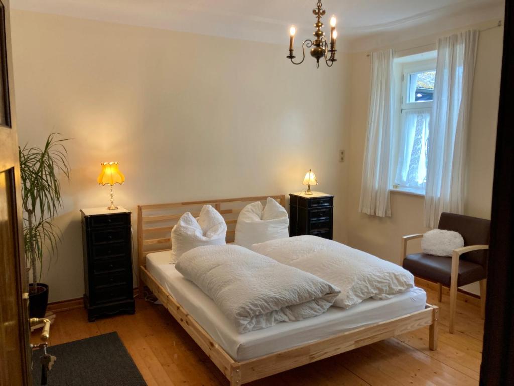 Schlafzimmer mit einem Bett mit weißer Bettwäsche und Kissen in der Unterkunft Hinkelshof in Körperich