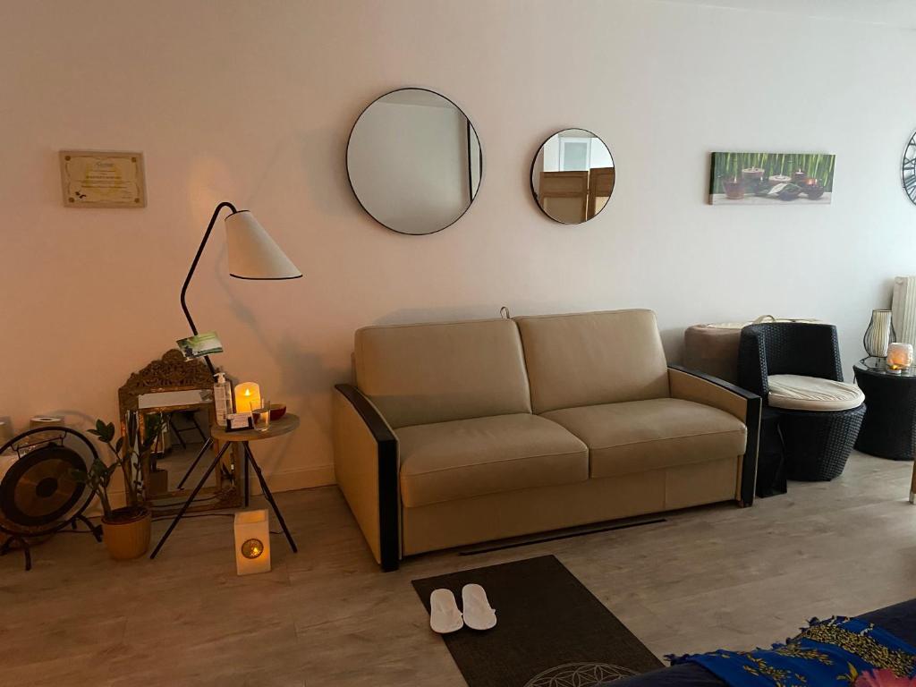 - un salon avec un canapé et des miroirs sur le mur dans l'établissement STUDIO 35 M2 AVEC TERRASSE, à Paris