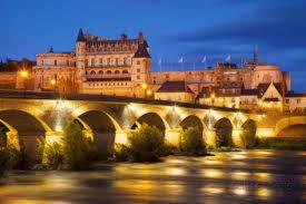 a bridge over a river in front of a large building at Appartement De Charme in Amboise