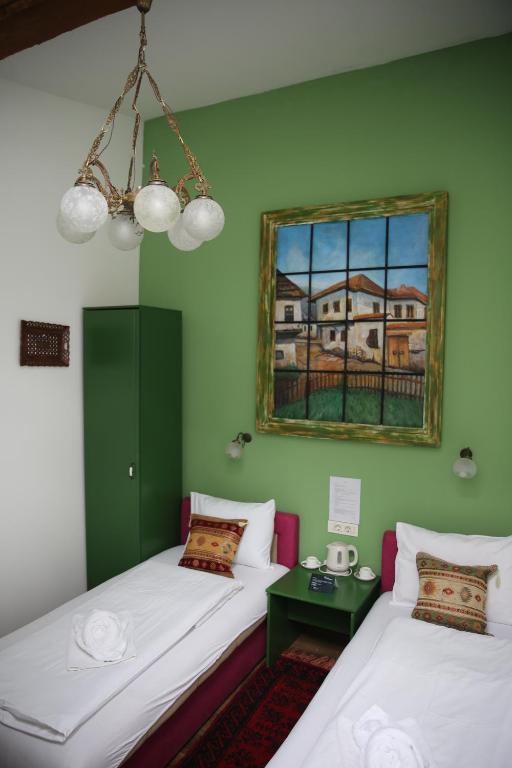 2 camas en una habitación con un cuadro en la pared en Guesthouse Yildiz 2 en Sarajevo
