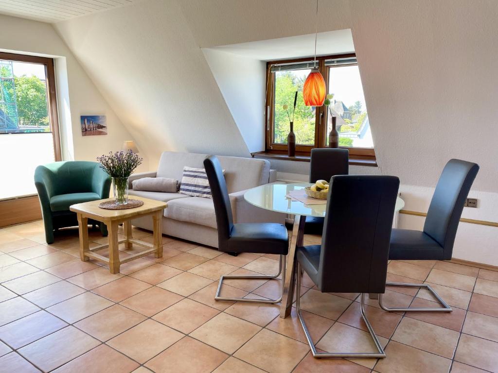 un soggiorno con divano, tavolo e sedie di Andersen OG a Westerland