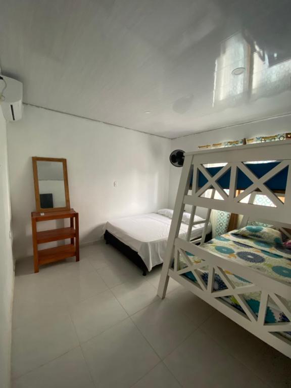 a bedroom with a bunk bed and a mirror at Rutymar crab in Necoclí