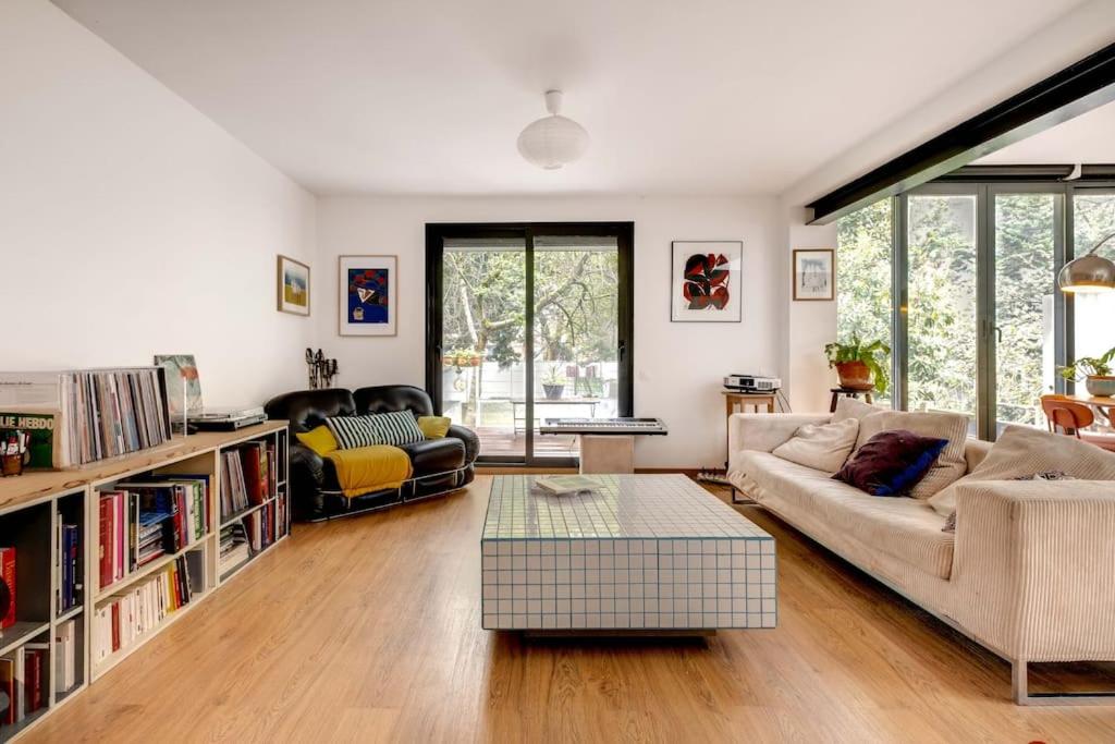 un salon avec un canapé et une table dans l'établissement Maison proche village olympique, à Saint-Denis