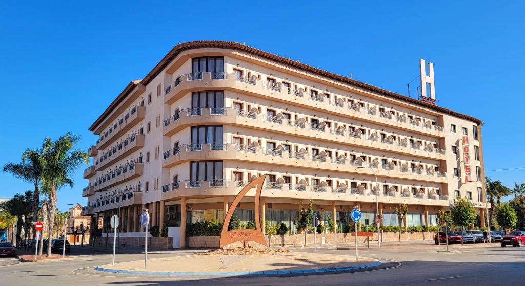 un grand bâtiment avec une sculpture devant lui dans l'établissement Hotel Monarque Costa Narejos, à Los Alcázares