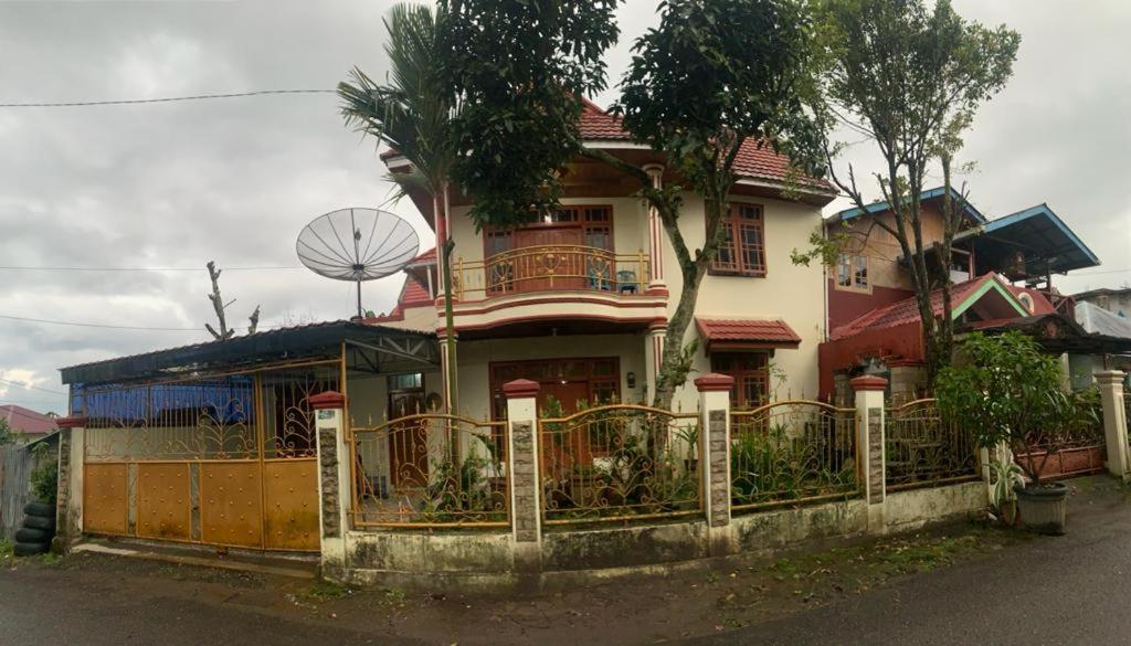 ein Haus mit einem Zaun davor in der Unterkunft Garuda Homestay in Bukittinggi