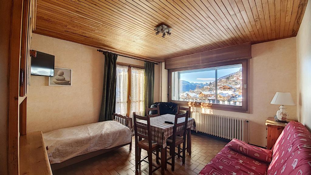 une chambre avec un lit, une table et une fenêtre dans l'établissement Grand Vane 4, à Morzine