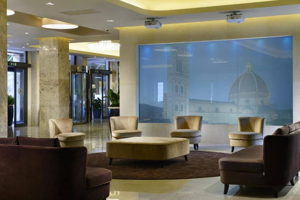 un hall avec des chaises et une grande photo d'un bâtiment dans l'établissement FH55 Grand Hotel Mediterraneo, à Florence