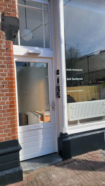 a door to a store with a reflection in the window at BnB Souterrain in Amsterdam