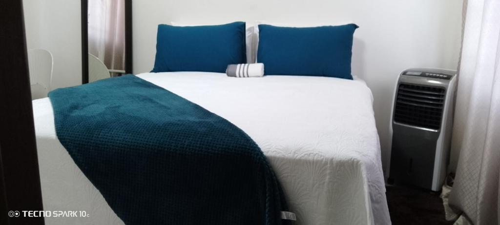 sypialnia z łóżkiem z niebieskimi poduszkami w obiekcie Sunset Shades w mieście Francistown
