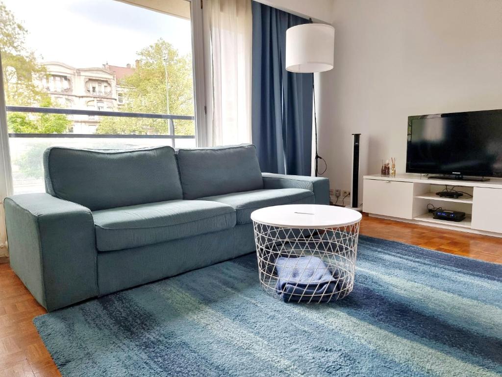 a living room with a couch and a tv at Florya Studio Woluwe in Brussels