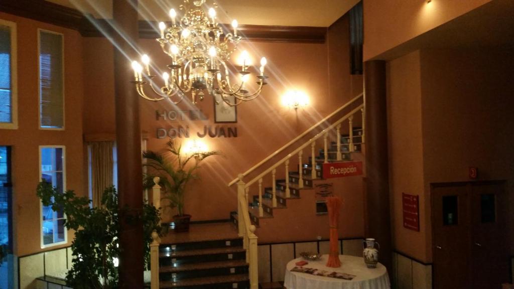 una lámpara de araña colgada en un edificio con una escalera en Hotel Don Juan, en Navalvillar de Pela